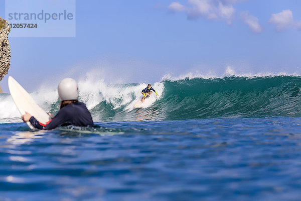 Indonesien  Bali  Surferin beobachtet eine andere Frau beim Surfen