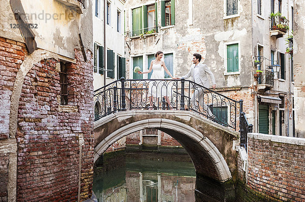 Italien  Venedig  Brautpaar läuft auf kleiner Brücke