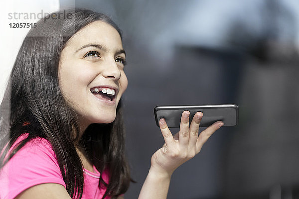 Mädchen in rosa Hemd spricht mit jemandem auf ihrem Smartphone
