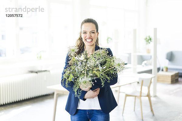Porträt einer glücklichen Geschäftsfrau mit Blumentopf