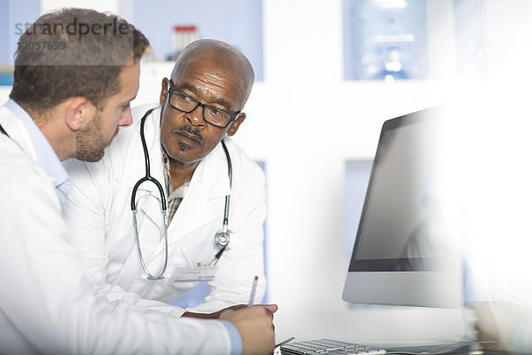Zwei Ärzte diskutieren am Computerbildschirm
