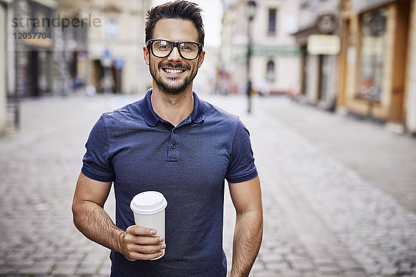 Porträt eines lächelnden Mannes mit Gläsern  die im Freien Kaffee halten
