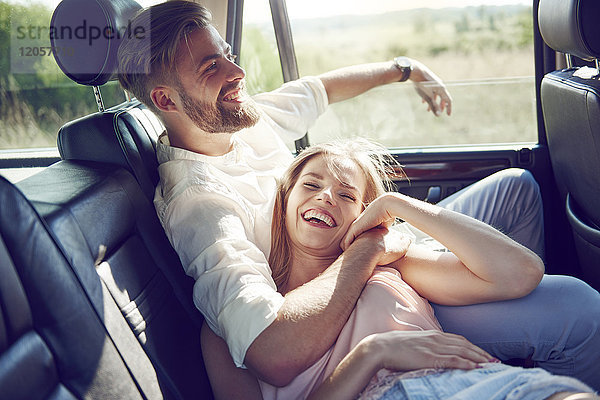 Glückliches junges Paar entspannt im Auto