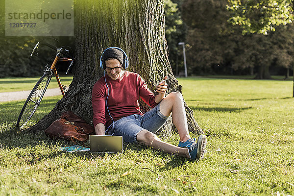 Mann mit Laptop im Park