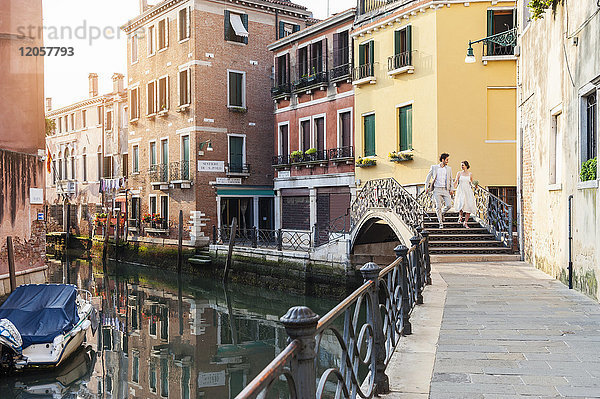 Italien  Venedig  Brautpaar  das auf einer kleinen Brücke läuft