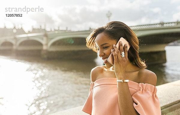 UK  London  Frau am Telefon in der Nähe der Westminster Bridge