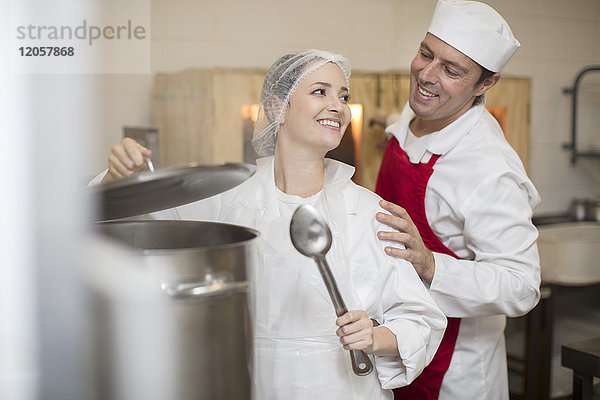 Mann und Frau beim Kochen in der Großküche