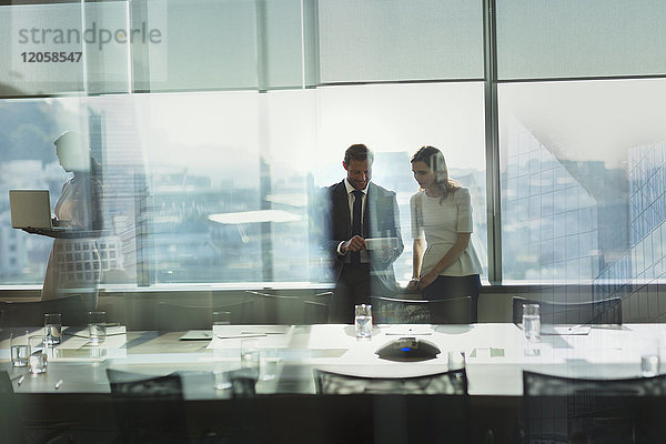 Geschäftsmann und Geschäftsfrau arbeiten mit einem digitalen Tablet in einem städtischen Konferenzraum