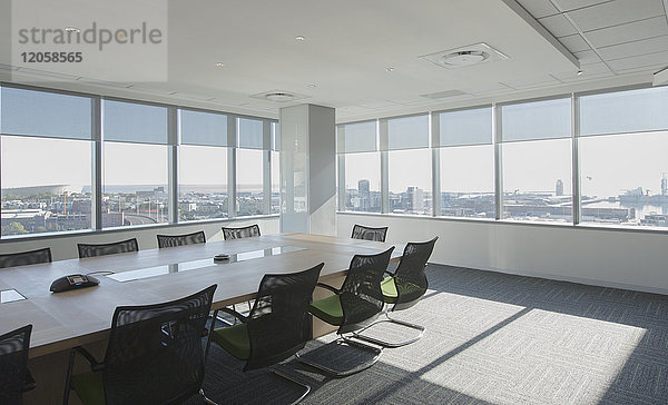 Stühle und Konferenztisch in einem sonnigen städtischen Konferenzraum