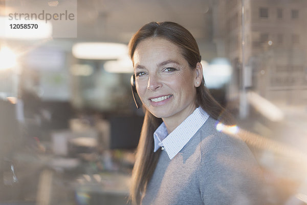 Porträt einer lächelnden  selbstbewussten Geschäftsfrau mit Headset im Büro