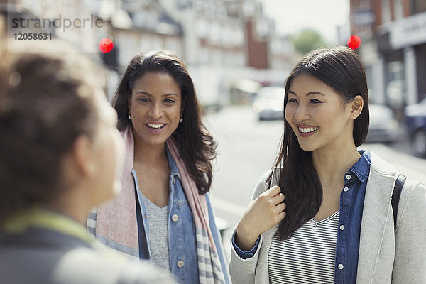 Lächelnde Frauen  die sich auf der Straße unterhalten