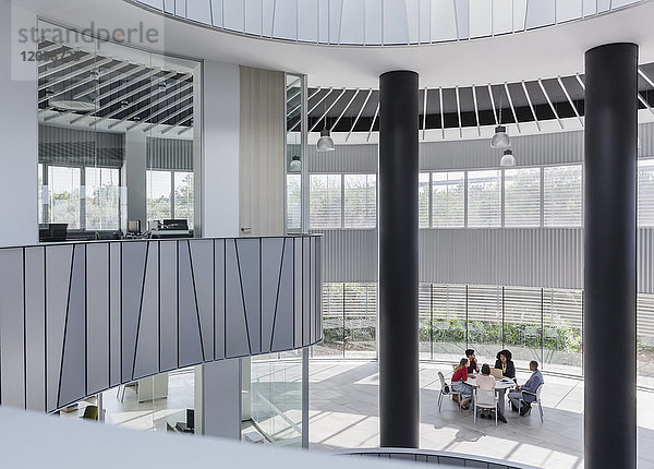 Geschäftsleute treffen sich am Tisch im architektonischen  modernen Büroatrium