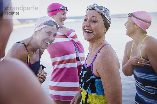 Lachende Schwimmerinnen  die mit Handtüchern abtrocknen.