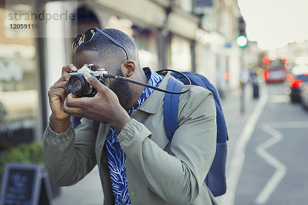 Junge männliche Touristen fotografieren mit Kamera auf der Straße