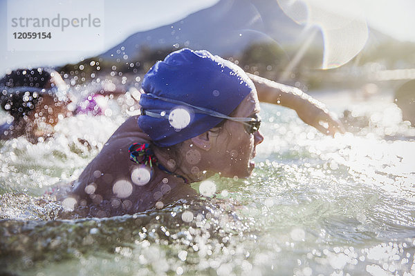 Entschlossene Schwimmerin  die im sonnigen Meer schwimmt.