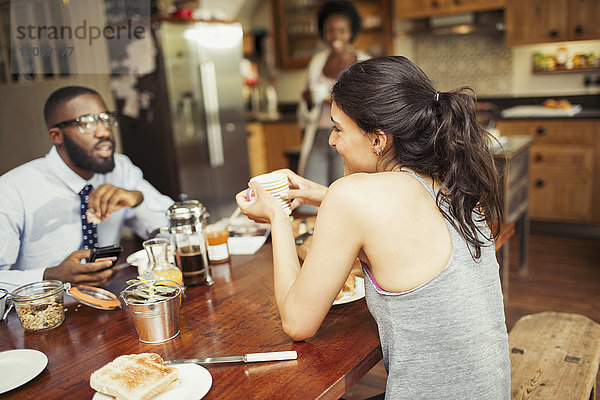 Ein Paar trinkt Kaffee und frühstückt am Tisch.
