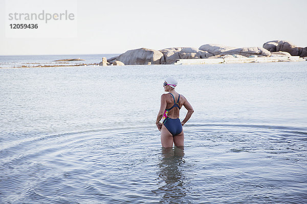 Weibliche Freiwasserschwimmerin stehend  im Meer watend