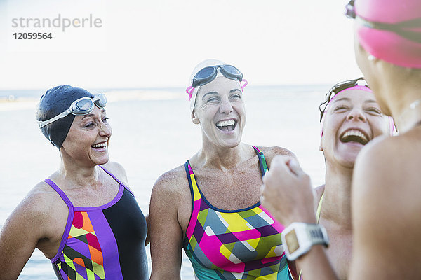 Lachende Schwimmerinnen im offenen Wasser sprechend