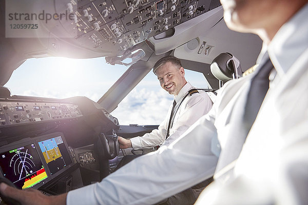 Portrait lächelnder  selbstbewusster Pilot im Flugzeugcockpit
