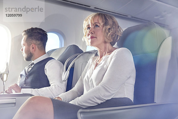 Geschäftsfrau sitzend in der ersten Klasse im Flugzeug