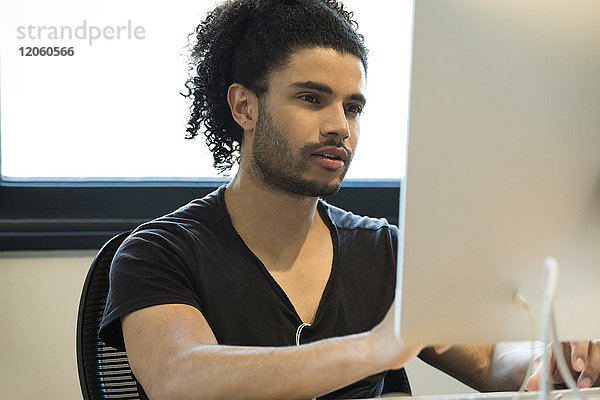 Junger Mann mit Desktop-Computer