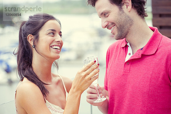 Mann und Frau klirren mit Champagner.