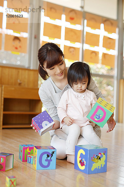 Erzieherin mit Kind im japanischen Kindergarten