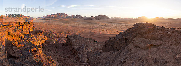 Wüstenlandschaft mit Felsen bei Sonnenuntergang.