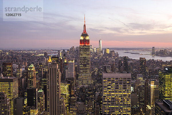 Stadtlandschaft von Manhattan  New York  USA  in der Abenddämmerung  Blick nach Süden  mit dem beleuchteten Empire State Building in der Mitte.