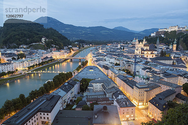 Hochwinkelansicht über die Dächer einer Stadt an einem Fluss  in der Ferne ein Schloss auf Bergen.