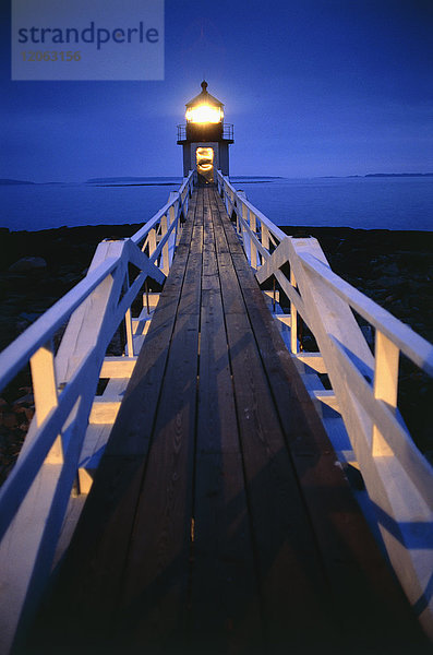 Abends beleuchteter Holzsteg zum Leuchtturm.