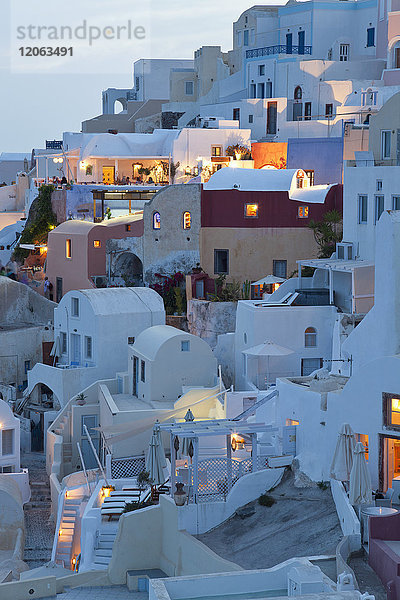 Hochwinkelaufnahme von traditionellen weiß getünchten Häusern auf einer griechischen Insel in der Dämmerung.