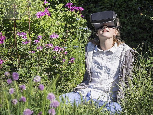 Mädchen mit Virtual-Reality-Headset im Garten