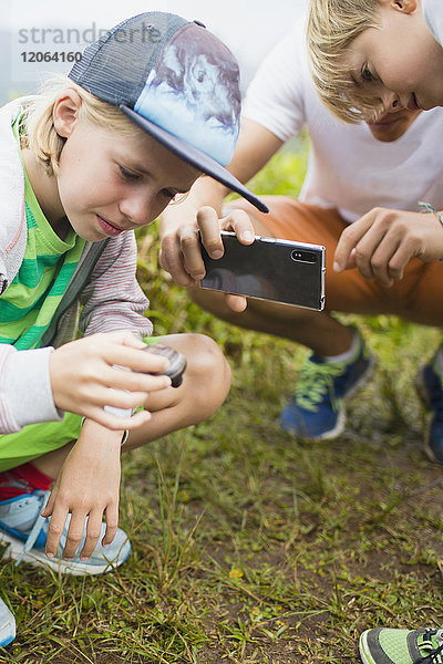 Kinder mit Vater fotografieren Schnecke mit Handykamera
