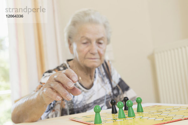Ältere Frau spielt Brettspiel im Altersheim