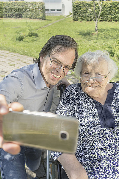 Sohn macht Selfie mit behinderter Mutter im Rollstuhl