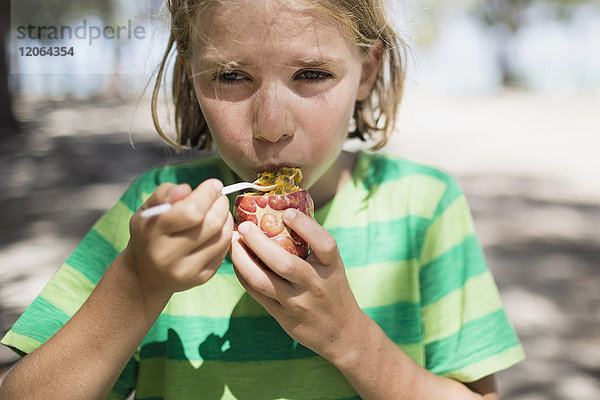Porträt eines Mädchens  das eine Passionsfrucht isst
