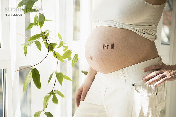 Schwangere Frau mit Strichlistensymbol auf dem Bauch