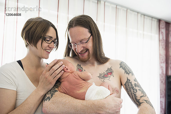 Glückliche Eltern halten ihr neugeborenes Baby