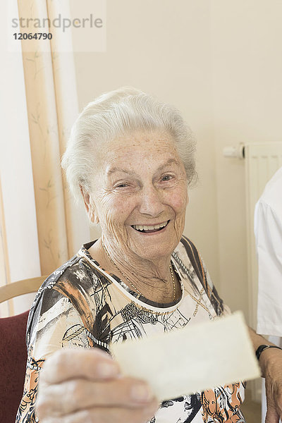 Ältere Frau betrachtet Foto im Altersheim