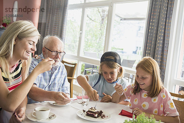 Familie isst Kuchen im Altersheim