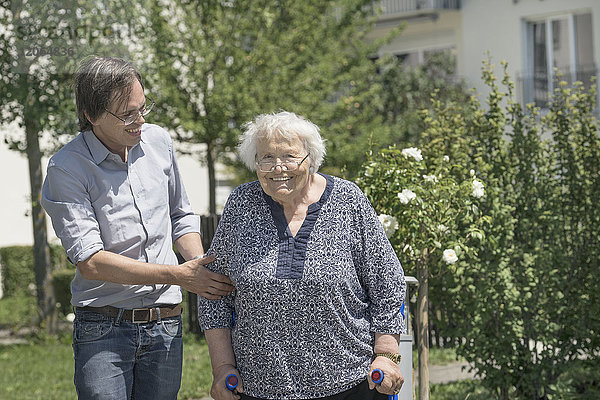 Sohn geht mit behinderter Mutter auf Krücken