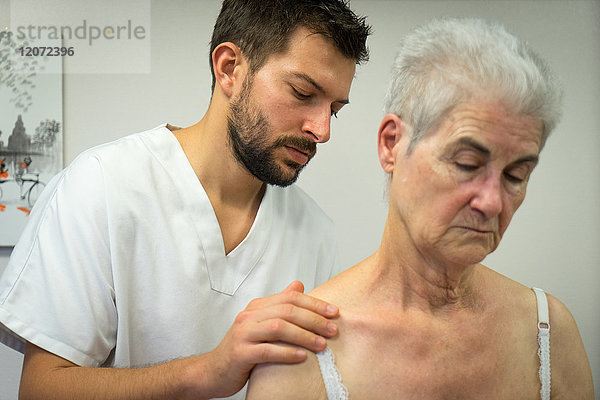 Reportage in einer Osteopathie-Praxis in Héyrieux  Frankreich. Osteopathiesitzung bei einer 74-jährigen Frau  die unter Verspannungen im Genitalbereich leidet  die die Energiekommunikation zwischen Bauch und Becken beeinträchtigen.