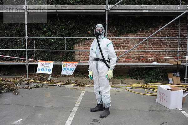 Ein Arbeiter trägt vor der Asbestsanierung in Nordfrankreich Schutzkleidung.