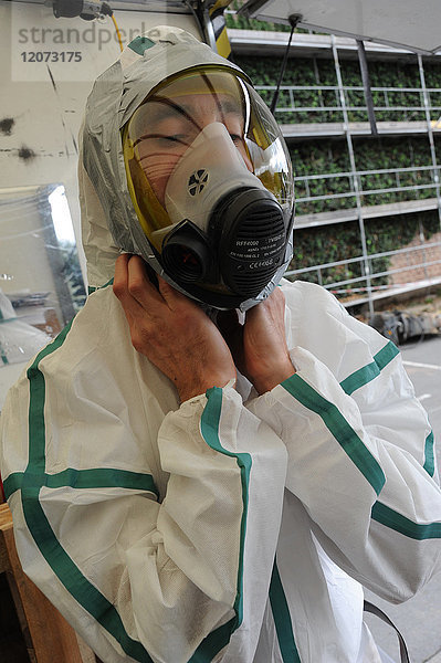 Vorbereitung eines Arbeiters auf einer Asbestsanierungsbaustelle in Nordfrankreich. Die vorgeschriebene Kleidung für jeden Arbeiter besteht aus einem Overall  einer Maske  Stiefeln und Handschuhen.
