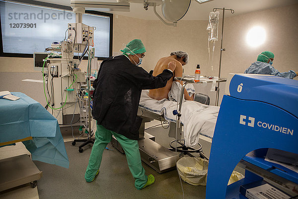 Reportage aus der Entbindungsstation des Krankenhauses Métropole Savoie in Chambéry  Frankreich. Eine geplante Entbindung per Kaiserschnitt. Der Anästhesist legt mit Hilfe einer Krankenschwester die Epiduralanästhesie.