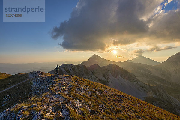 Wanderer vor dem Berg Portella bei Sonnenuntergang  Gran Sasso e Monti della Laga National Park  Abruzzen  Italien  Europa