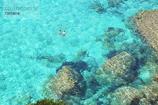 Menschen schwimmen im smaragdgrünen Wasser von Cala Mitjana  Menorca  Balearen  Spanien  Mittelmeer  Europa
