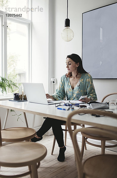 Geschäftsfrau mit Laptop auf dem Tisch im Home-Office