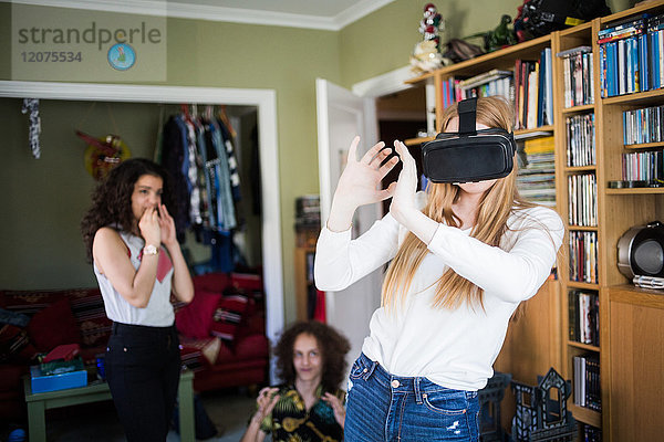 Blondes Mädchen mit Virtual-Reality-Headset von Freunden zu Hause